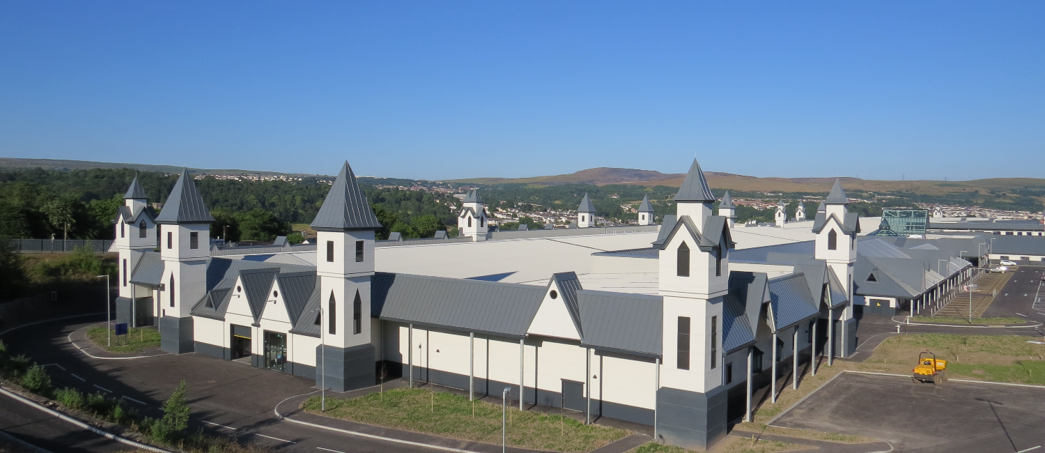 Trago Mills building in Merthyr Tydfil, a white structure with towers along the walls, and a large flat roof